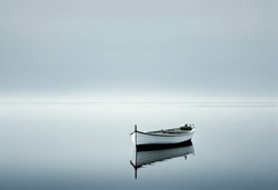 a solitary boat on a serene lake, under a clear sky, representing peace and simplicity.in style of minimalism. underscoring the calming simplicity and the quiet beauty of the Nature