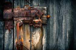 Old rusty padlock on wooden door