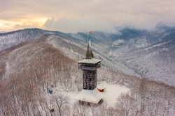 Aerial view of Millennium Lookout Tower which can be reach by foot from Szalajka-Valley near Szilvásvárad, Heves, Hungary. Winter landscape with cloudy sky.