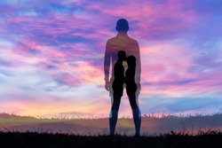 Silhouette man on grass with sunset background
