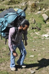 Selective focus of a male tourist walking in the mountain with carrying parachute bag