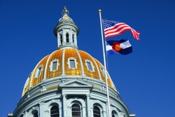 The American and Colorado flags at the Colorado state capitol building in Denver. 
