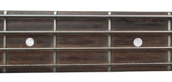 A close up shot of the fretboard of a bass guitar. 
