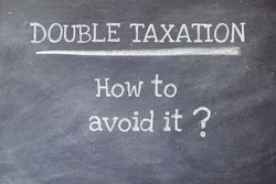 Blackboard background with the text Double Taxation How to avoid it. Double Taxation Avoidance Agreement concept.