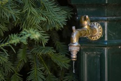 Last drops of water coming from a rusty garden tap or outdoor faucet, water shortages and heatwaves in Europe concept, hydration
