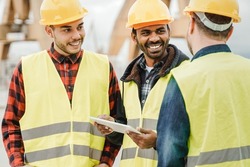 Multiracial engineer workers working at construction site using tablet computer - Focus on indian man face