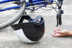 bicycle and a helmet lying on the road with hand of human, accident concept