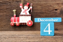 December 4th, Wooden calendar showing date on 4 December with Christmas decoration on wooden table.