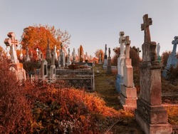 Crosses on abandoned graves. Christian religious monuments. Old cemetery in autumn. Forgotten burial places.