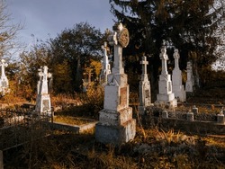Old European cemetery with crosses. Abandoned graves on a sunny autumn morning. Monuments of Christianity.