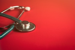Stethoscope on red, reflective background