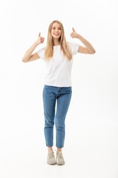 Lifestyle Concept: Happy smiling young woman in jeans looking at the camera giving a double thumbs up of success and approval isolated on white