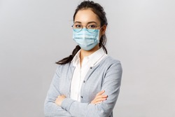 Covid19, virus, health and medicine concept. Portrait of young confident professional asian nurse, taking care of patients, wearing medical mask during quarantine coronavirus, cross hands chest