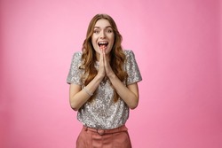 Excited attractive girlfriend eager start pack ready travel abroad win tickets press palms together happily thrilled looking amused feeling happiness standing pink background glamour outfit