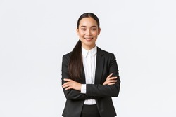 Successful young asian businesswoman in suit ready do business, cross arms confident and smiling. Female entrepreneur determined to win. Happy saleswoman talking to clients, white background