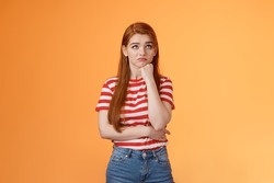 Upset redhead woman losing lottery feel uneasy distressed, look up regret loss, lean on fist pulling sad face, standing lonely unhappy orange background thinking, taking hard decision