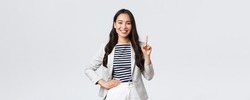 Business, finance and employment, female successful entrepreneurs concept. Good-looking confident female asian real estate broker being number one, offer good deal, showing finger and smiling