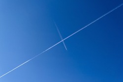Plane vapor trails crossing in sky
