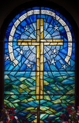 Stained glass window in a church on St Agnes, Isles of Scilly, U.K. Depicting a cross against the sky and sea.