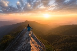 Meditation in great serenity at the top of a mountain rock in Taichung in Taiwan in front of the sun at sunset for great well being and wellness and energy