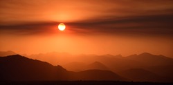 fiery sunset over the front range of the colorado mountains due to the smoke from  the western forest fires, as seen from broomfield, colorado