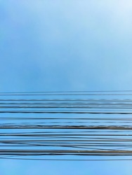 Communication wire on the post against the blue sky. Abstract background. Black cable lines on a gradient blue backdrop. Blue wallpaper with horizontal lines. Electrical cable. Wire networking.