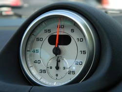 Analog watch in German sports car. Hours and minutes.