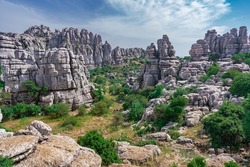 Karst landscape of Torcal de Antequera. Large valley with Mediterranean vegetation surrounded by vertical limestone rock walls. From Malaga, Andalusia, Spain.