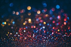 Neon bokeh background with blue, yellow and pink colors on dark. Blur halftone glitter texture. Blurred night lights glow.