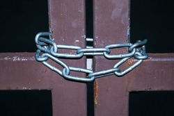 Close up detail with a old metal gate locked with a metal chain