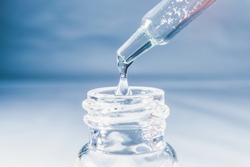 Close-up pipette with a hyaluronic moisturizing serum in a glass bottle with a pipette on a white background Beauty skin care concept Beauty and spa.