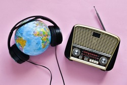 Retro radio, headphones and globe on pink background. World radio day. world music day. Top view, flat lay, top view