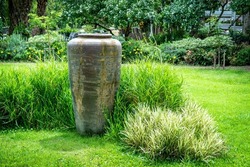 Big jar decoration in the garden. Pottery earthen jar or water jar decorative in the park background.