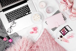 Fashion blogger workspace with laptop and woman accessory in bed. flat lay,  top view