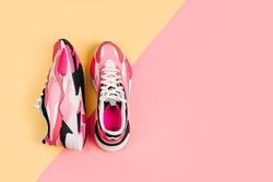 Bright female sneakers on pink background. Fashion blog or magazine concept. Women's shoes, trendy sneakers, fashion, style, lifestyle. Flat lay top view copy space minimal background.