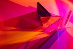 Multicolored glass on colorful gradient background. The light travels through different acrylic sheets. Stylish abstract background