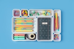 Stylish colored school stationery is arranged in organizers. Creative Drawer Organizing. Storage office supplies. Concept back to school. 
