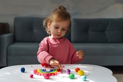 A little girl playing with rainbow from play dough for modeling. Art Activity for Kids. Fine motor skills. Sensory play for toddlers.	