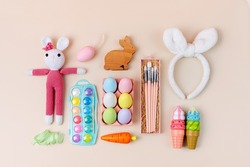 Ideas for kids Easter Basket gifts. Knitted Bunny, Easter eggs, sweets and material for creativity and art activity. Holidays decorations and gifts