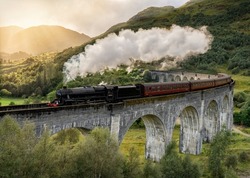 Steam train crossing the Glenfinnan viaduct in the Scottish Highlands, Scotland United Kingdom. Made famous in the Harry Potter movies
