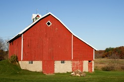 A small red barn and a woodpile on a Wisconsin farm.