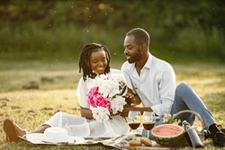 African american couple with flowers on a summer picnic