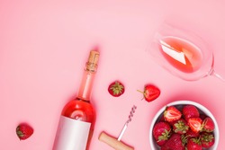 Creative composition with rose wine and delicious strawberries on the pink background, top view