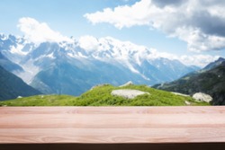 Empty wooden table on the background of scenic mountain Alpine landscape. Template for montage