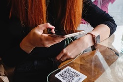 Woman scanning the barcode qr code in restaurant or cafe