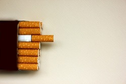 A pack of cigarettes on a white background. open pack of cigarettes. Yellow filter. Harm to health. It is a bad habit. The concept of World No Tobacco, Tobacco and Lung Health. Cigarettes in a tutu.