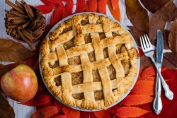 Vegan caramel apple pie with fall leaves in a Thanksgiving setting