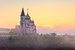 Orthodox church on the outskirts of the city in the morning fog at dawn. Krasnoyarsk, Siberia, Russia
