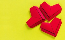 paper hearts on a yellow background, the concept of love, the day of St. Valentine's Day,Red origami hearts on yellow background,
