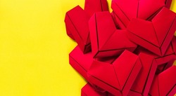 paper hearts on a yellow background, the concept of love, the day of St. Valentine's Day,Red origami hearts on yellow background,